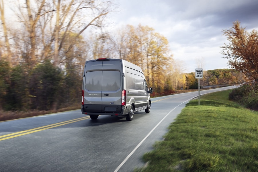 A 2025 Ford Transit® van being driven down a road