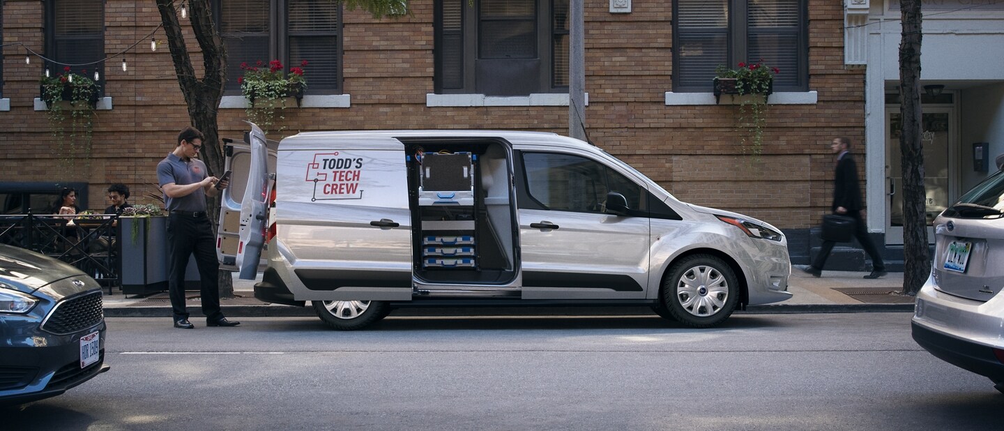 2023 Ford Transit Connect Cargo Van parked in the city shown with available rear swing cargo doors