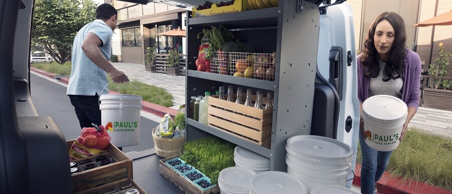 Small-business owners utilizing cargo area of 2023 Transit Connect Cargo Van with aftermarket upfitted shelving