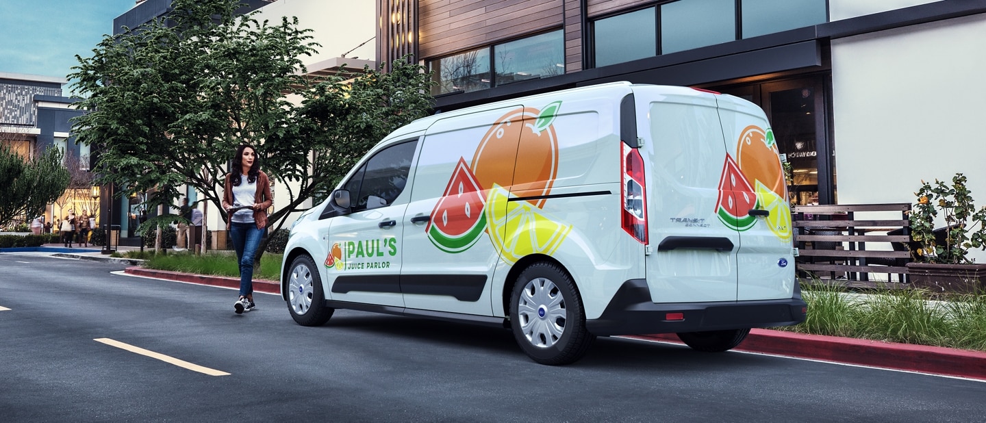2023 Ford Transit Connect Cargo Van with business graphics parked on city street