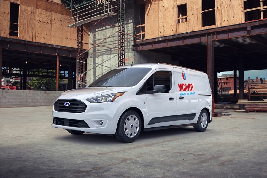 2023 Ford Transit Connect Cargo Van in Frozen White with aftermarket business graphics parked in construction site
