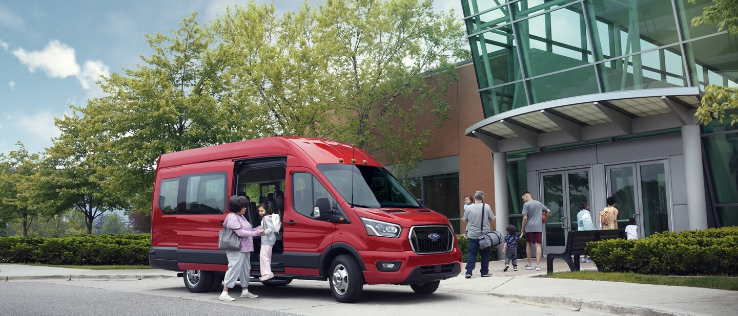 A woman helping a child out of a 2023 Ford Transit® van