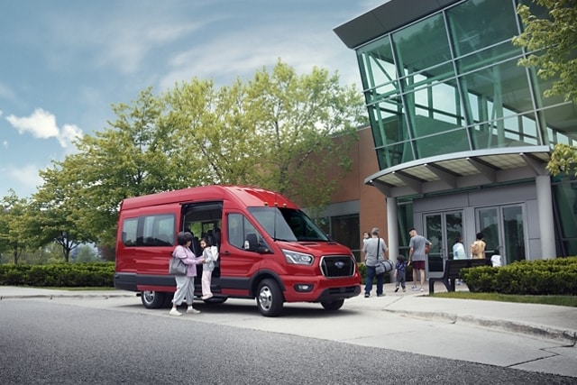 A woman helping a child out of a 2023 Ford Transit® van