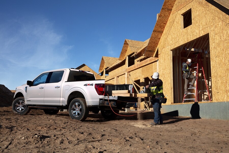 A man cutting wood on the tailgate of a 2023 Ford F-150®